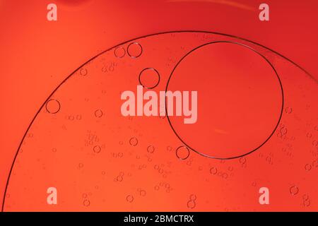 Circular shapes of seprerated oil on the surface of water - creative macro background Stock Photo