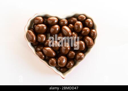 Milk Chocolate Covered Peanuts in a Heart Shaped Bowl Stock Photo