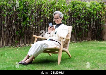 An Asian elderly woman is using a smartphone Stock Photo