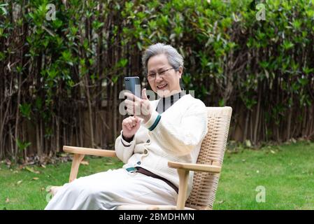 An Asian elderly woman is using a smartphone Stock Photo