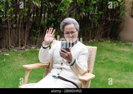 An Asian elderly woman is using a smartphone Stock Photo