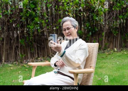 An Asian elderly woman is using a smartphone Stock Photo