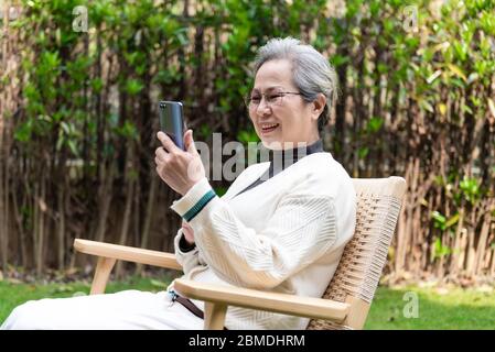 An Asian elderly woman is using a smartphone Stock Photo
