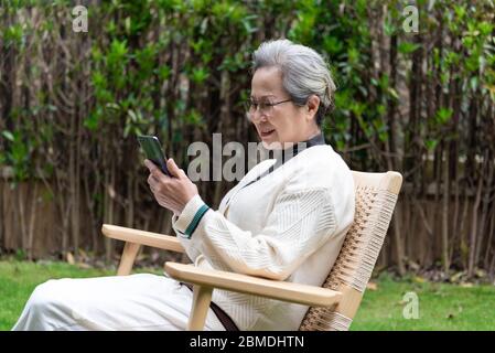 An Asian elderly woman is using a smartphone Stock Photo