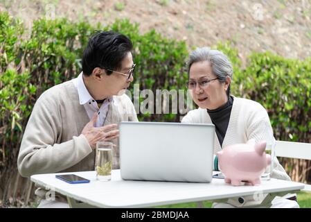 An Asian elderly couple is using a laptop Stock Photo