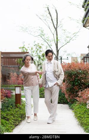An Asian elderly couple walking in the community Stock Photo