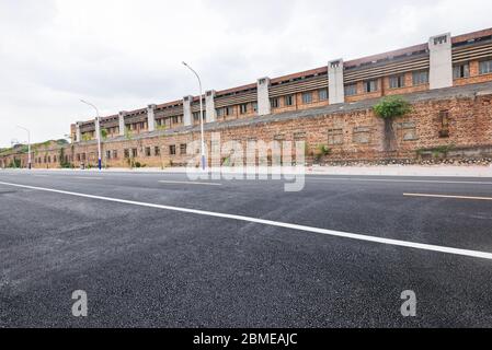 Asphalt road straight ahead outdoors in old industrial area. Stock Photo