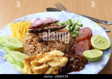 Rice mixed with shrimp paste consisting of sweet pork, chinese sausage, fried eggs, cucumber slice, sour mango, shallot, yard long bean, roasted peppe Stock Photo