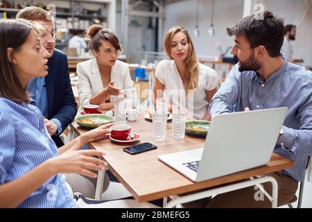 Group of young and creative people at the table,working on  laptop and discussing. Stock Photo