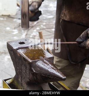 Detail shot of hammer forging hot iron at anvil Stock Photo
