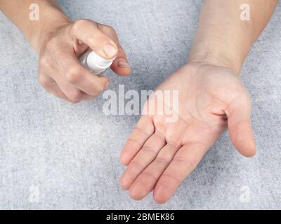 holds an antiseptic spray, disinfects the hands of the bacteria, virus covid-19 . white background,top view, close-up. health concept, hygiene, antiba Stock Photo