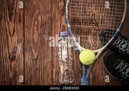 Tennis on a dark background. sneakers, rocket, ball, bottle of water Stock Photo