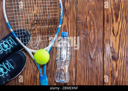 Tennis on a dark background. sneakers, rocket, ball, bottle of water Stock Photo