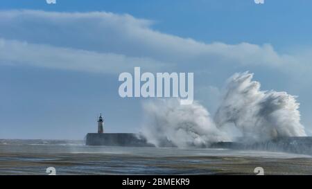 Huge waves crash over harbour wall onto lighthouse during huge storm on English coastline in Newhaven, amazing images showing power of the ocean Stock Photo