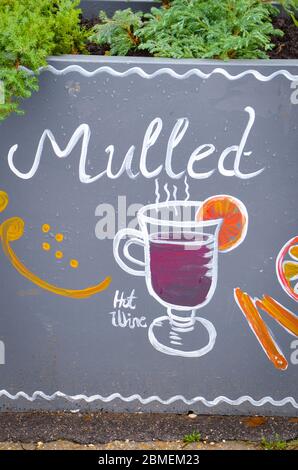 Budapest, Hungary - Nov 6, 2019: Handwritten sign mulled and simple drawing of a mulled wine glass with orange and cinnamon. Original ad attracting people to buy hot wine in the winter season. Stock Photo