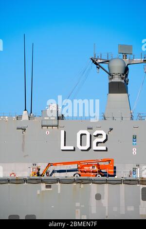 A red cherry picker high access lift on a warship in port Stock Photo