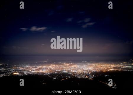 Glowing City Almaty lights at night sky with stars, Kazakhstan. Stock Photo