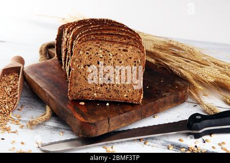 Sliced rye bread on cutting board. Whole grain rye bread with seeds on rustic background Stock Photo