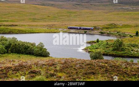 Inverness, Scotland, UK - September 25, 2013: A 2-car Scotrail passenger train travels along the Kyle Line railway beside a river in the remote Highla Stock Photo