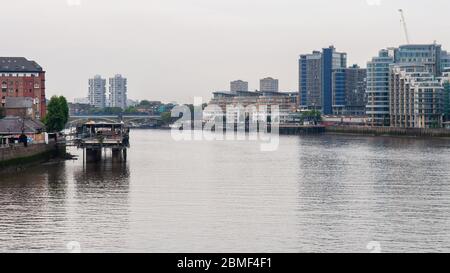 London, England, UK - June 18, 2013: A freight train crosses the River Thames on the West London Line's Battersea Railway Bridge, beside high rise tow Stock Photo