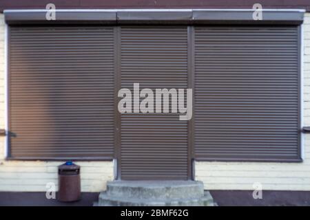 A brown metal shutter door, on a front modern commercial shop, with a copy space for text. Stock Photo