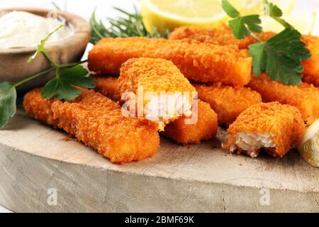 fresh fish fingers with remoulade sauce. breaded fish fingers with lemon Stock Photo