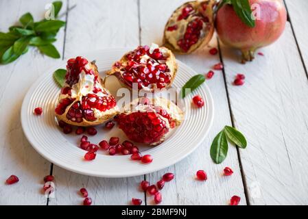 Fresh organic pomegranate with leaves on white background Stock Photo