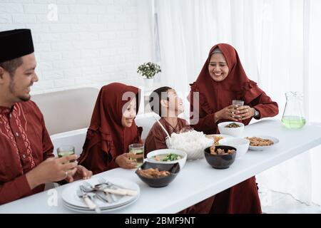 Muslim family sit to eat when breaking fast together at home Stock Photo
