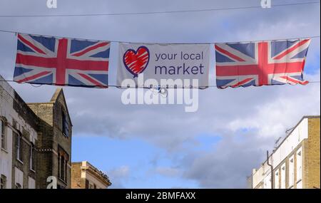 Street banner over Portobello Road with two Union Jacks and sign with Your Local Market and a heart. Portobello Road, Notting Hill, London, UK Stock Photo
