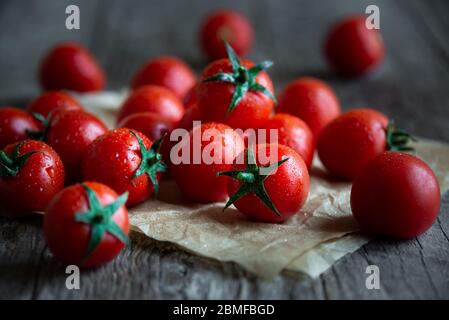 Fresh ripe organic cherry tomatoes on dark wooden background Stock Photo