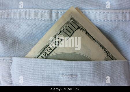 American money in the back pocket of blue jeans. Close-up of 100 dollars banknote. Stock Photo