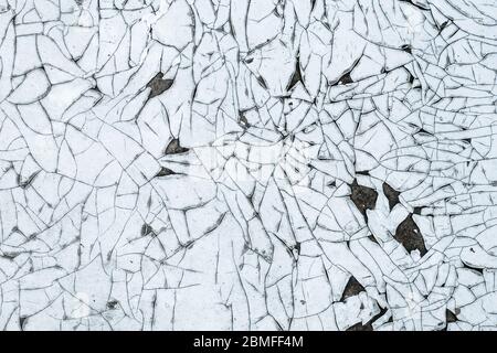 Cracked paint on the wall, flaky texture, white grunge background, abstract decorative wallpaper Stock Photo