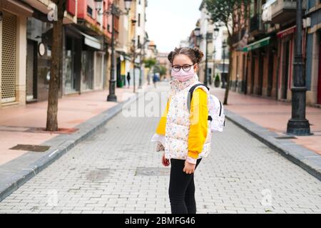 A girl with a mask on her face in the street of a city Stock Photo