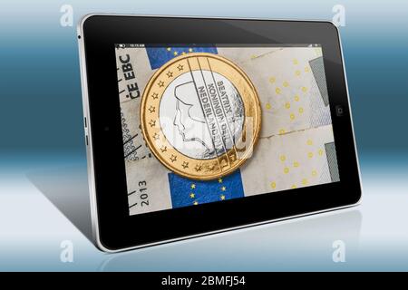 a 1 euro coin from the Netherlands on euro banknotes, view on a Tablet PC Stock Photo