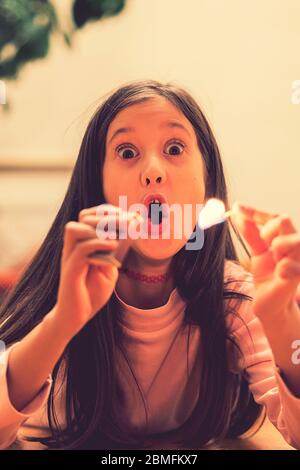 Girl playing with matches. Dangerous situation at home. A small child plays with matches, a fire, a fire flares up, danger, child and matches, lucifer Stock Photo