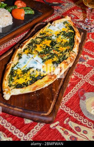 Traditional autyhentic turkish lunch or dinner: kebab with rice and vegetables, spinach and egg pide, pita flat bread and puff hot lavash or lavas hom Stock Photo