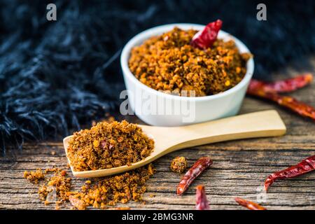 Spicy dried fishes chili paste with wooden spoon and background Stock Photo