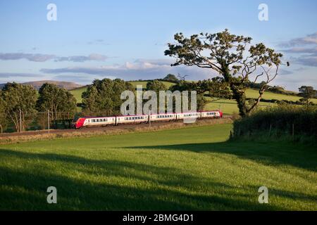 Virgin Trains Bombardier class 221 diesel voyager train in the countryside on the electrified west coast mainline in Cumbria. Stock Photo