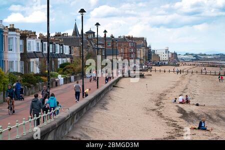 Portobello, Scotland, UK. 9 May 2020. Images from holiday weekend Saturday afternoon during Covid-19 lockdown on promenade at Portobello. Promenade and beach were relatively quiet with a low key police presence. Pictured; View along beach and promenade showing social distancing of people. Iain Masterton/Alamy Live News Stock Photo