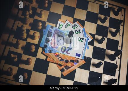Top view of chessboard with arranged pieces, money with black king on top in the center, success concept Stock Photo