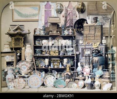 [ 1880s Japan - Japanese Curio Shop ] —   Curio shop lay-out in a studio. Items displayed vary from a samurai suit of armour to shinto shrines, furniture and porcelain.  19th century vintage albumen photograph. Stock Photo