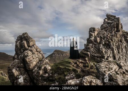 A cloaked figure wandering through a landscape beyond compare Stock Photo