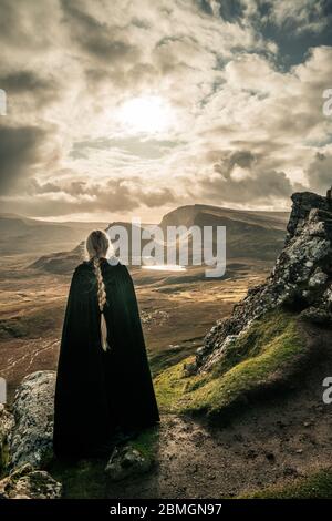 A cloaked figure wandering through a landscape beyond compare Stock Photo