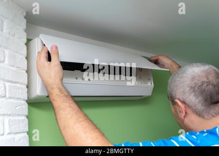 Male technician repairing and reading air conditioners. Opening the lid and repair diagnostics Stock Photo