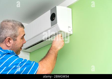 Male technician repairing and diagnosing air conditioners. Diagnostics for errors and preparation of a repair plan Stock Photo