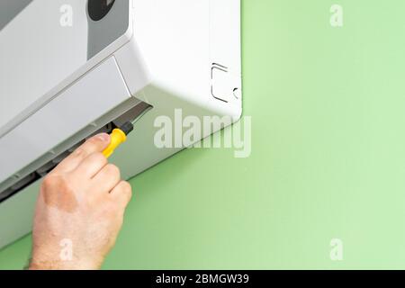 Male technician repairing and diagnosing air conditioners. Diagnostics for errors and preparation of a repair plan Stock Photo