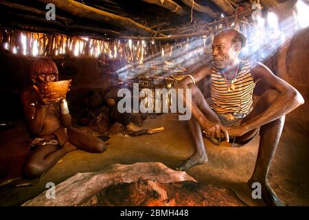 Sunbeams hit Shada the elder of the Kaina village and his wife Kaeske in their hut. Stock Photo