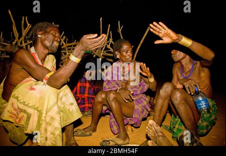 Stimulated conversation in front of the hut at nighttime. Stock Photo