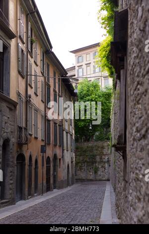 Traditional narrow Italian street and no people in Bergamo historical center, Italy. Medieval buildings. There's no one on the street. Stock Photo