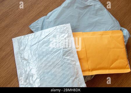 Three postal parcels small package white, gray and yellow lay on wooden background surface Stock Photo